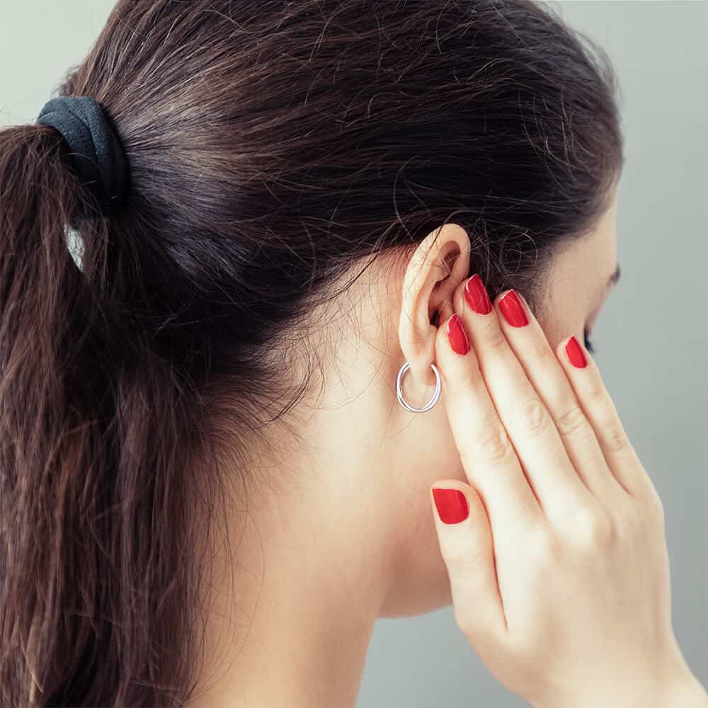Woman Holding Ear From Tinnitus